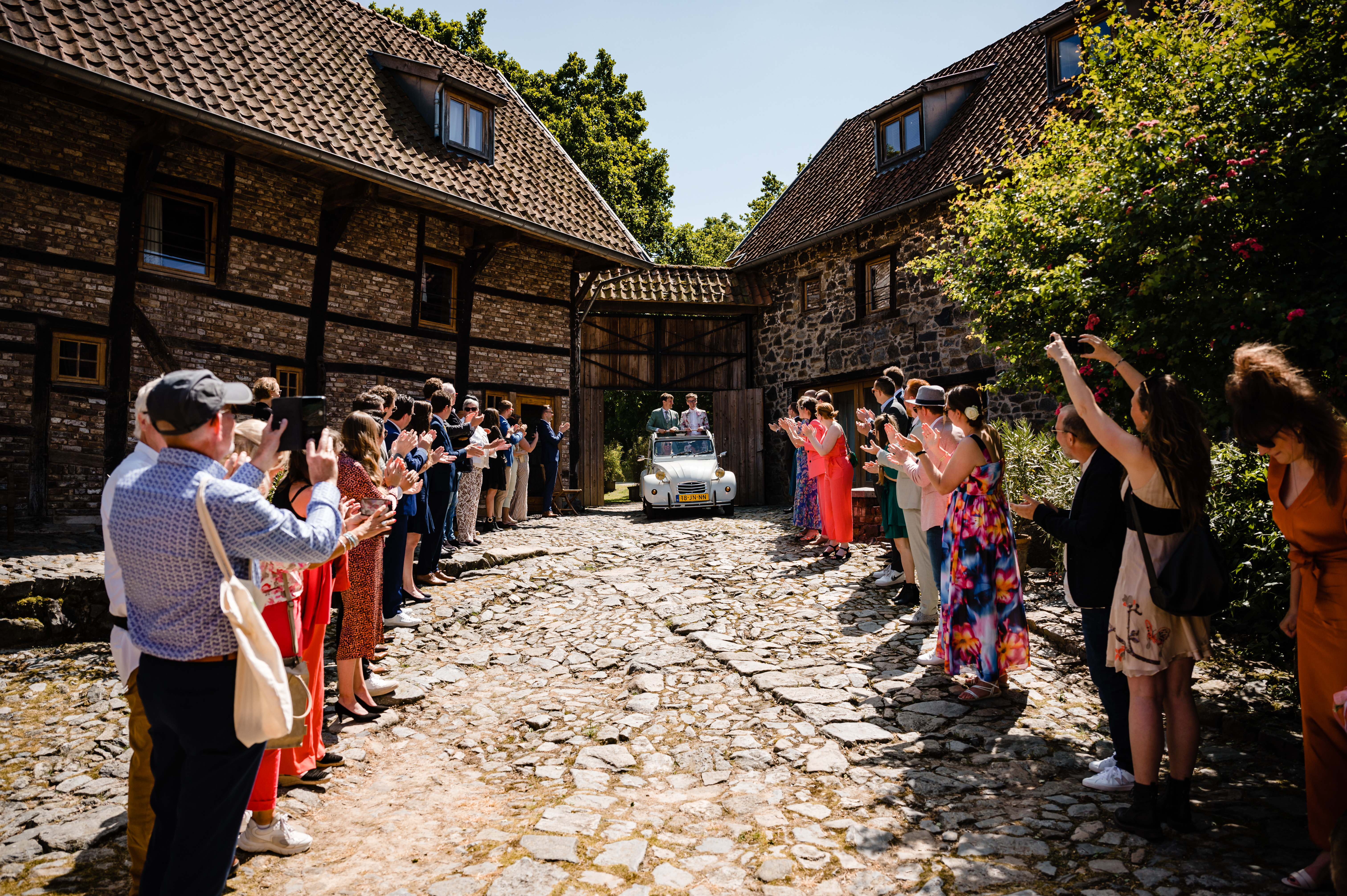 Hochzeitsauto verlässt den Innenhof von De Smockelaer unter Applaus
