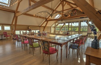 Rustieke vergaderruimte met houten balken en U-opstelling, passend bij een offsite meeting